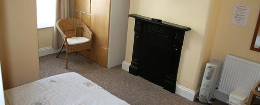 An image of a built in fireplace in a bedroom with a wardrobe and a dressing table.